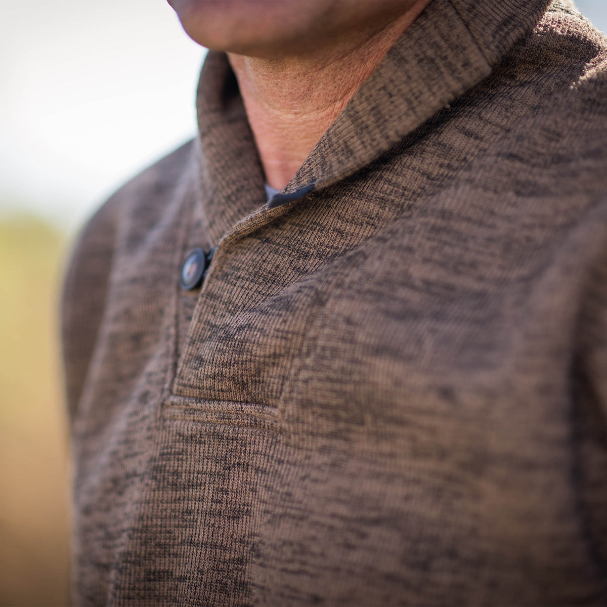 Detail of men's Olathe Pullover in Heather Chocolate color, featuring a button cowl neck.