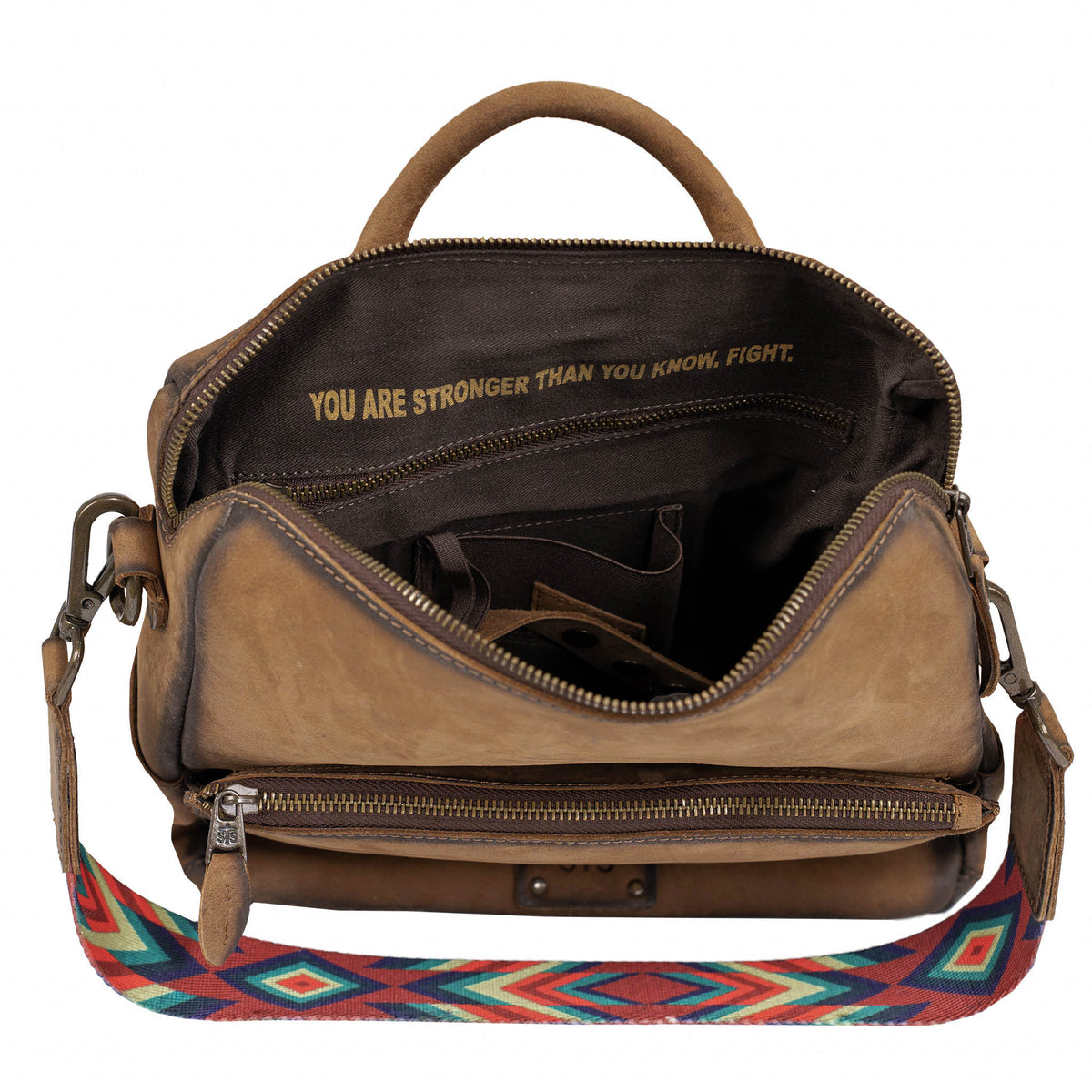 Interior of main compartment on brown leather backpack featuring concealed carry pocket and inspirational quote "You are stronger than you know, fight.".