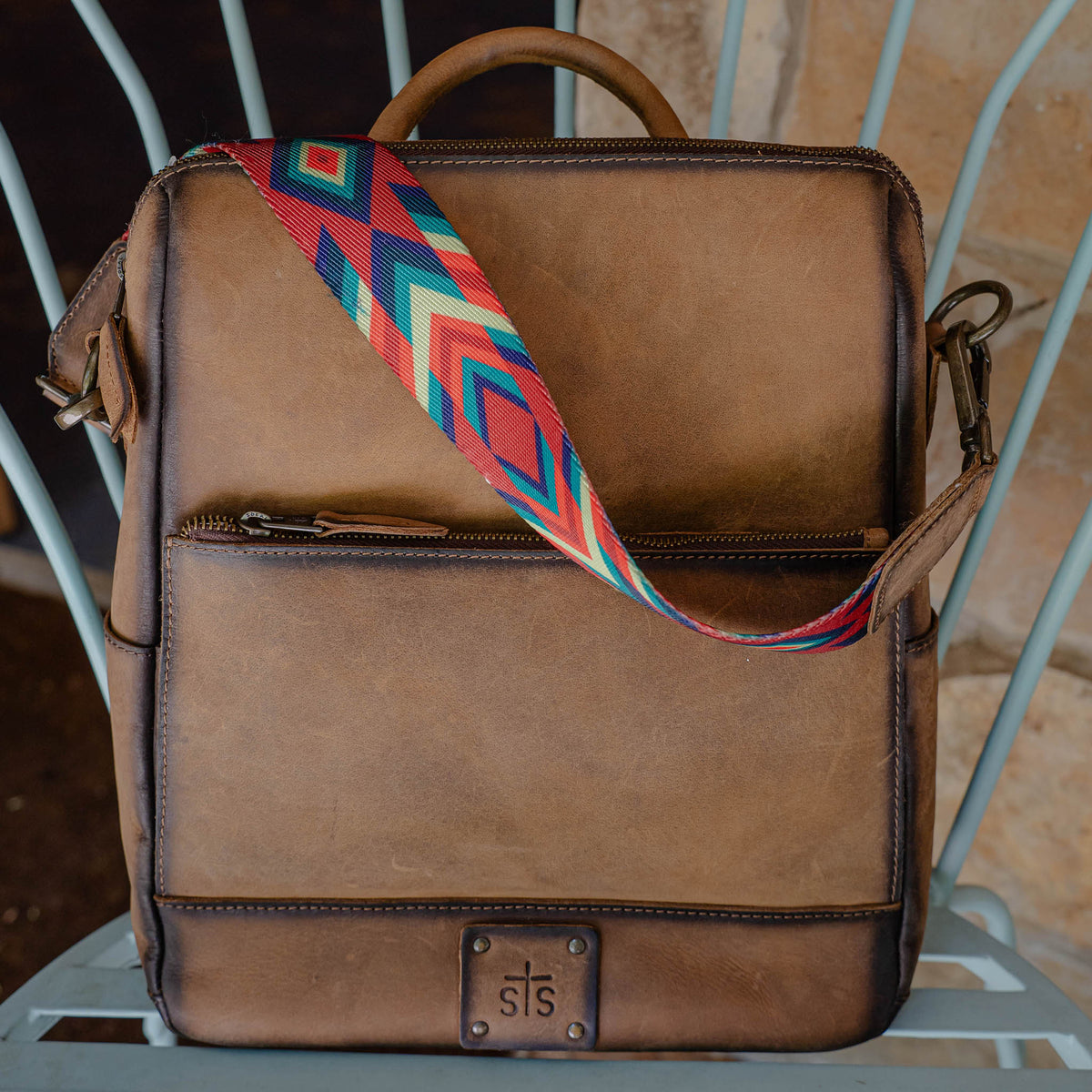 Brown leather backpack with leather handle and removable nylon shoulder strap.