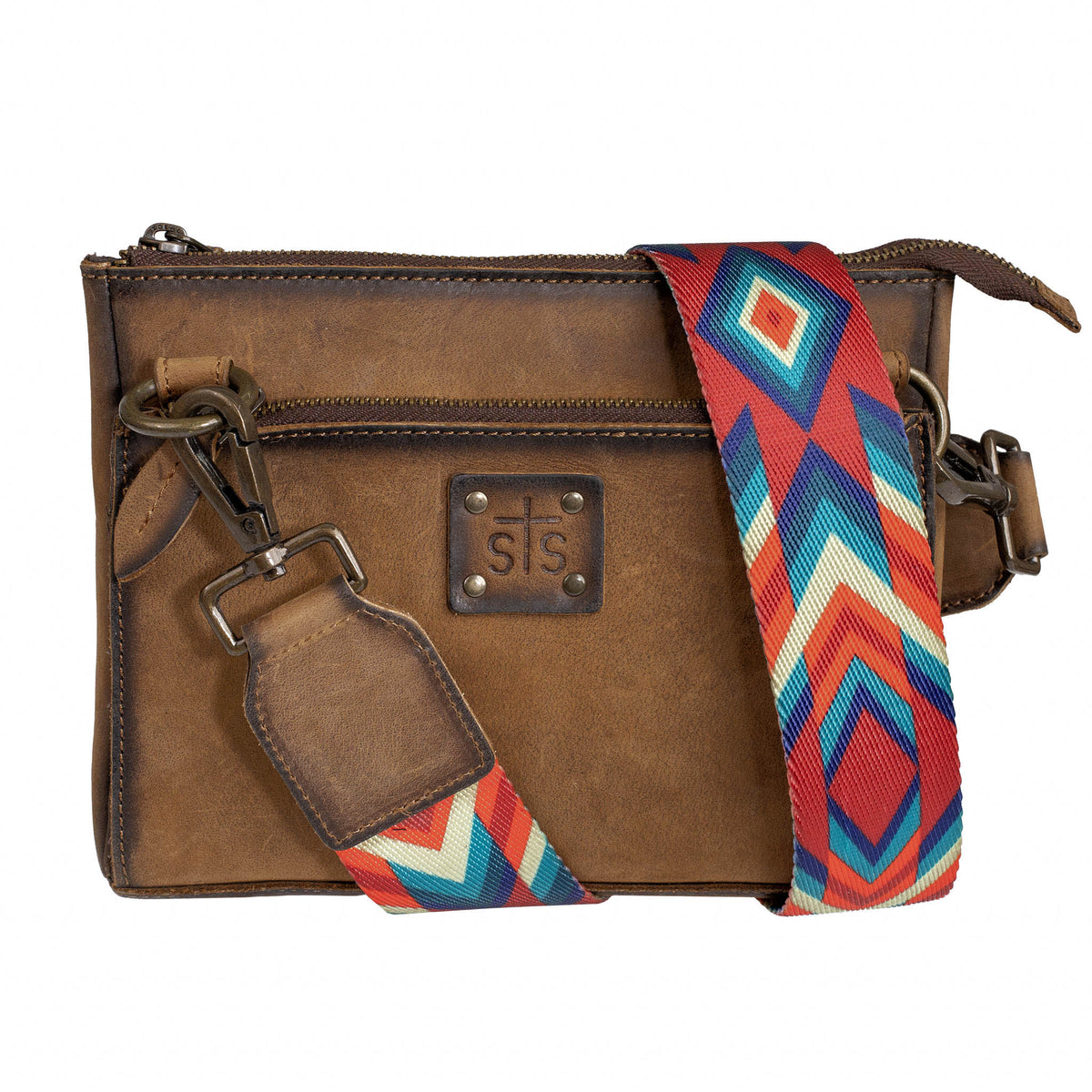 Brown leather crossbody bag with a colorful strap and zip top closure on a white background.