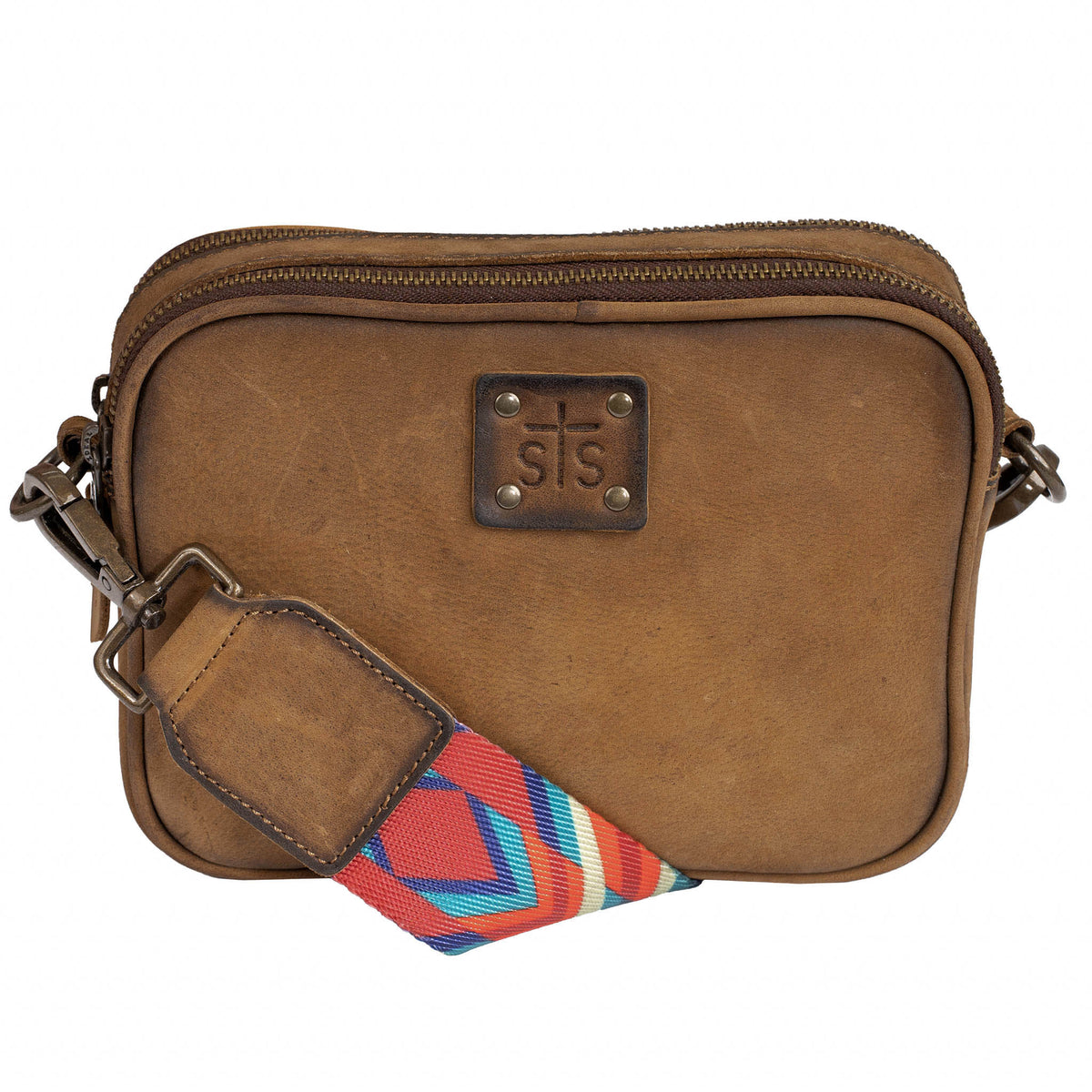 Brown leather crossbody bag with colorful strap and zip top closure on a white background.