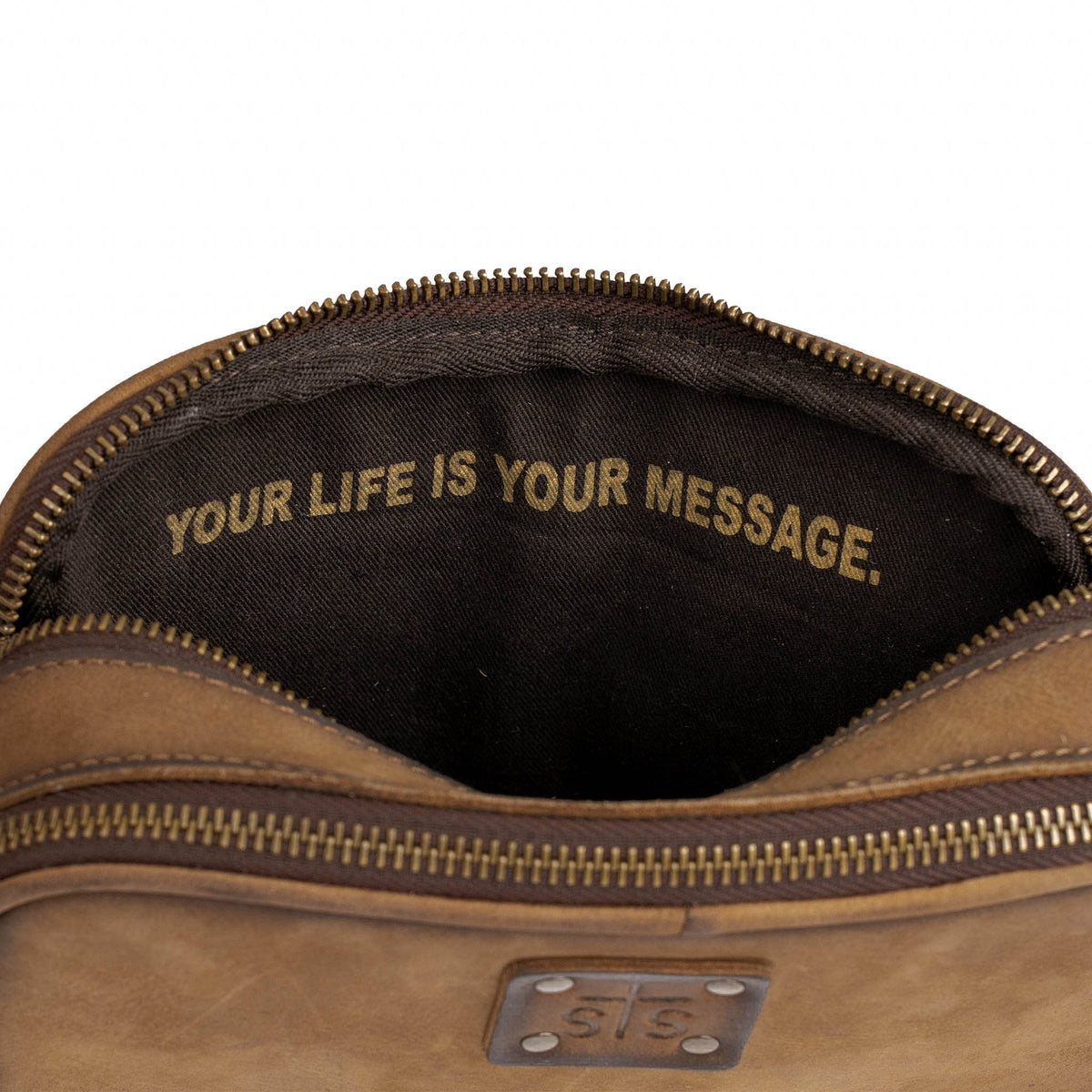 Brown leather bag with 'Your Life is Your Message' text on a white background.