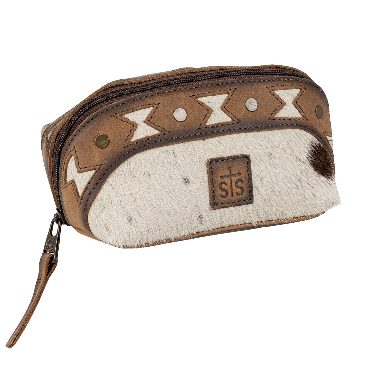 A makeup pouch with a mix of brown full grain leather and cowhide accents, featuring geometric aztec cut-outs, brown leather patch with STS Ranchwear embossed logo and zip top closure.