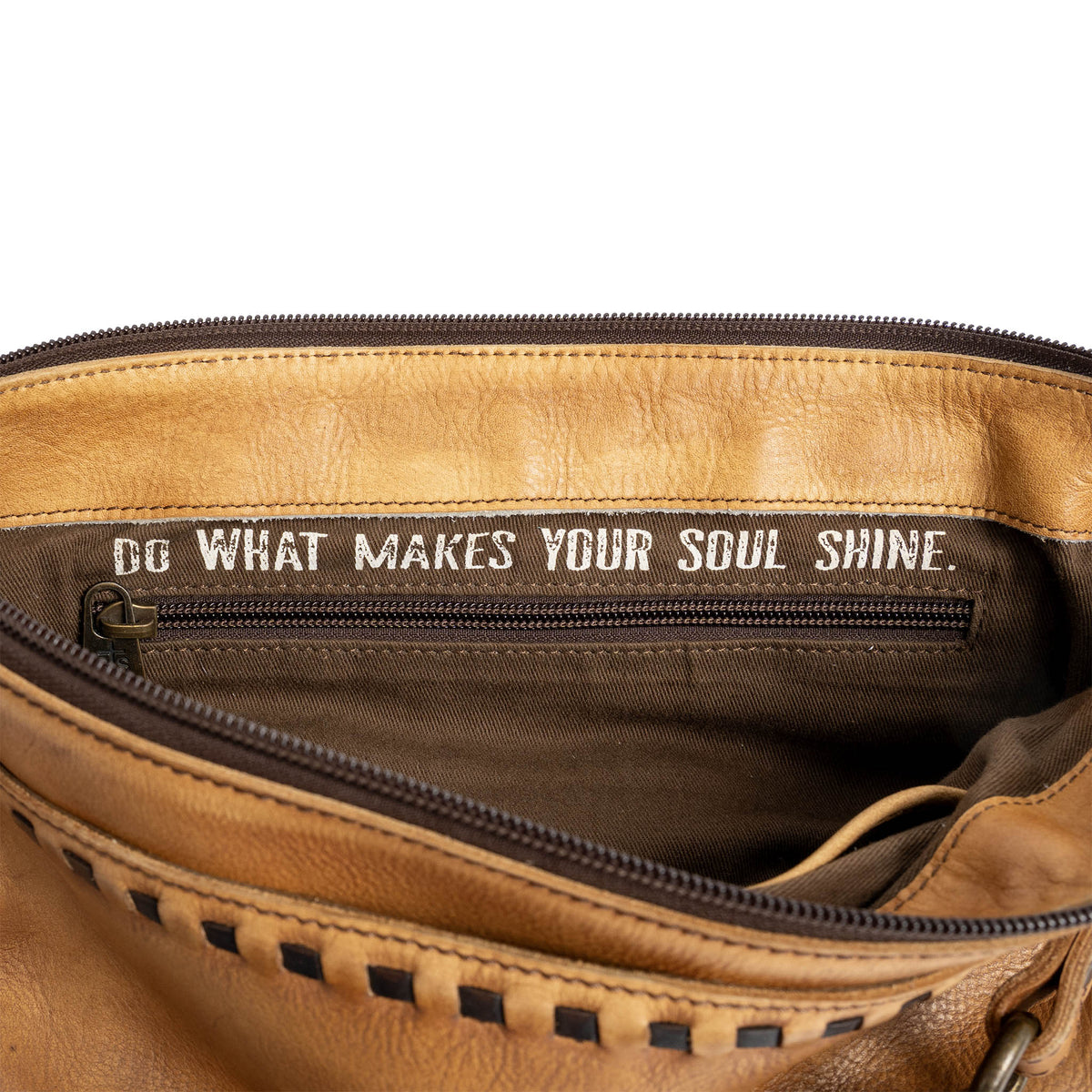 Brown leather bag with motivational quote "Do what makes your soul shine." inside.