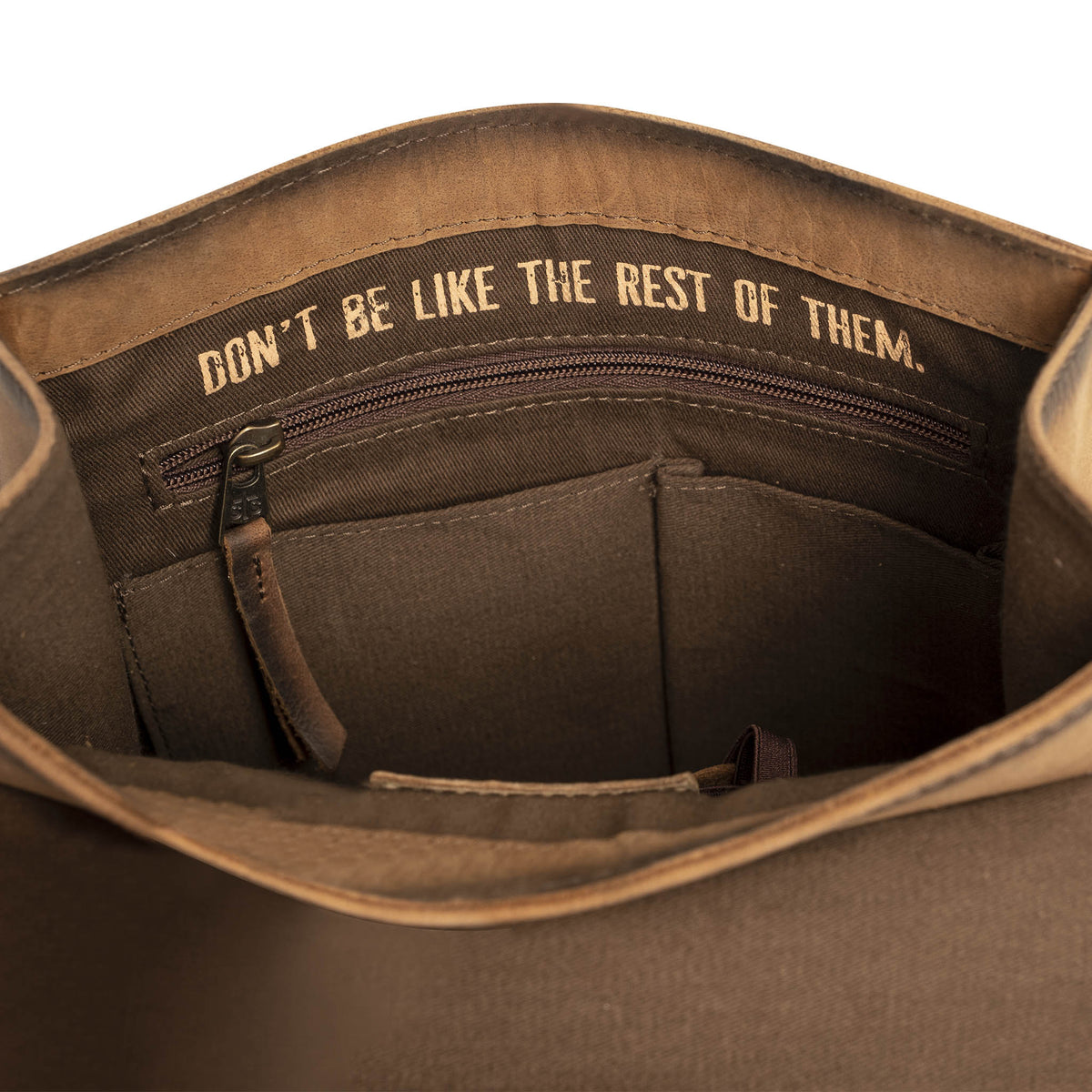 Inside main compartment with multiple pockets and inspirational quote "Don't be like the rest of them.".