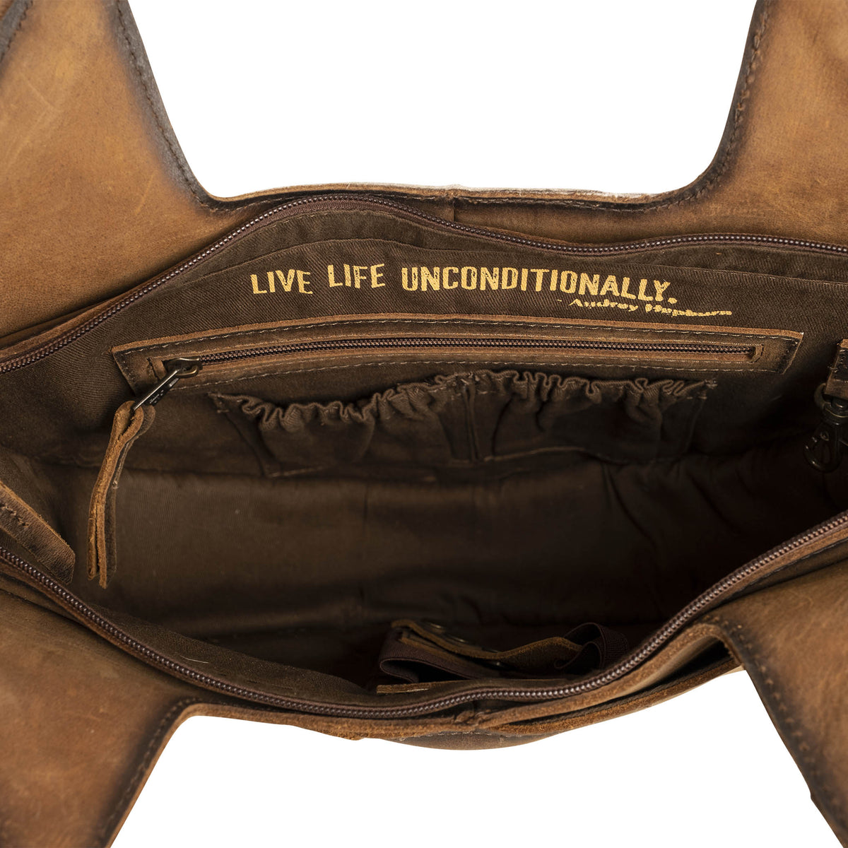 Inside main compartment with pockets and inspirational quote "Live life unconditionally.".