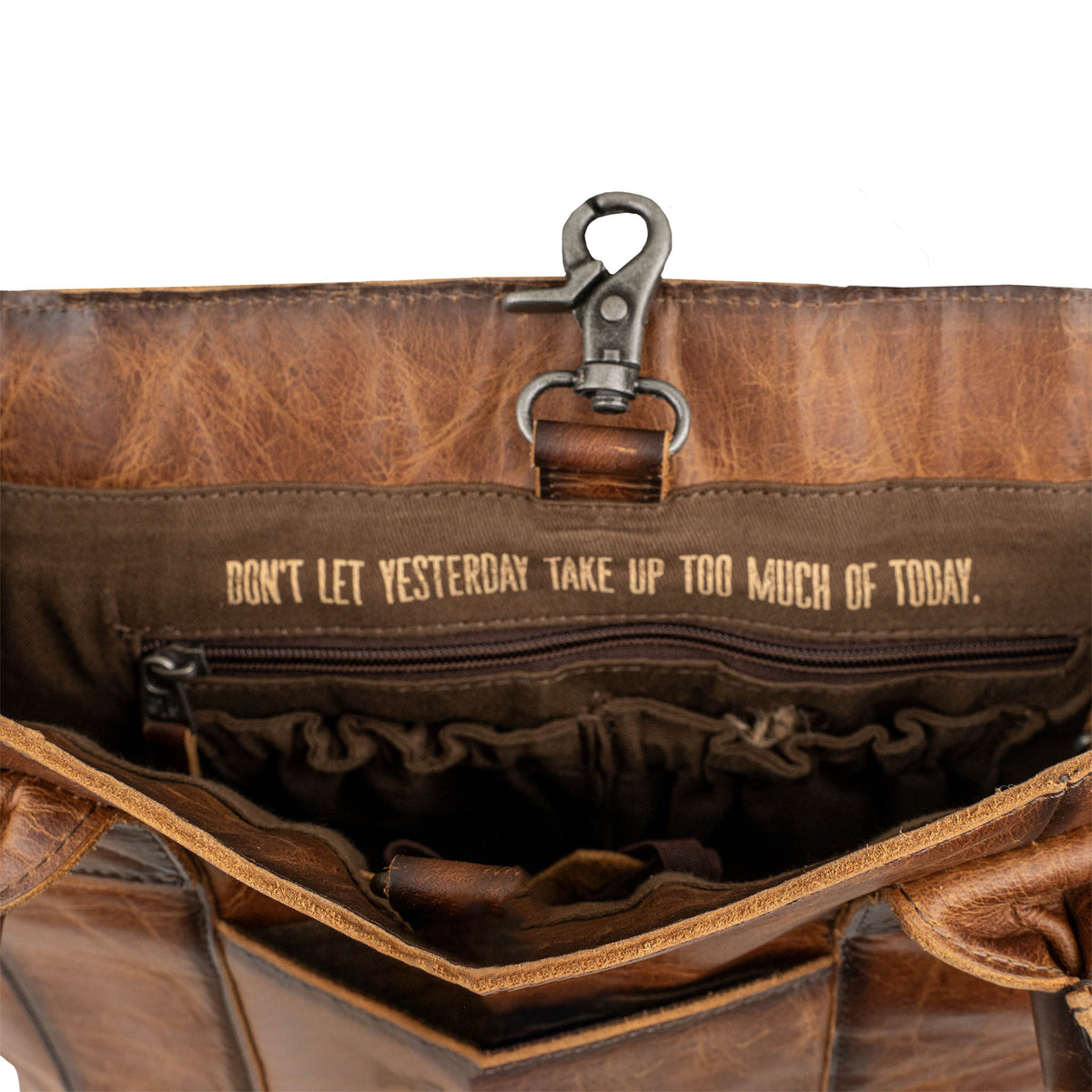 Interior of cowhide tote with lobster claw closing and inspirational quote "Don't let yesterday take up too much of today.".