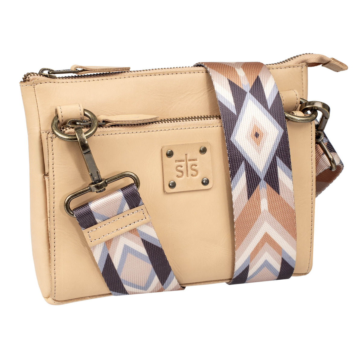 A beige leather crossbody with a top and front zip closure, a nylon strap, and an STS branded leather patch on a white background.