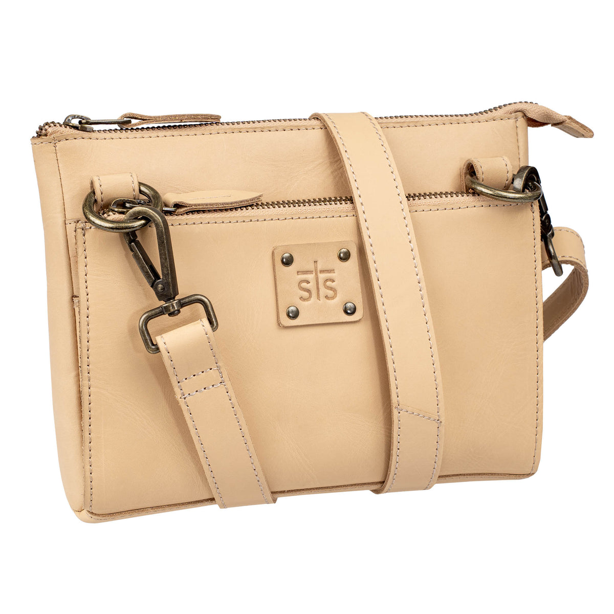 A beige leather crossbody with a top and front zip closure, a leather strap, and an STS branded leather patch on a white background.