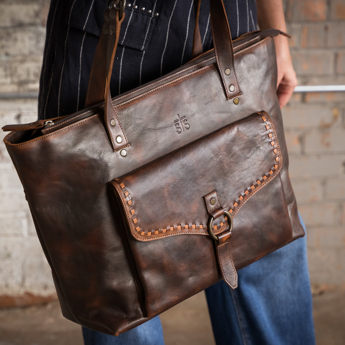 closeup of our Bandera chocolate leather tote purse with buckstitch, top zip closure and and magnetic buckle front pocket