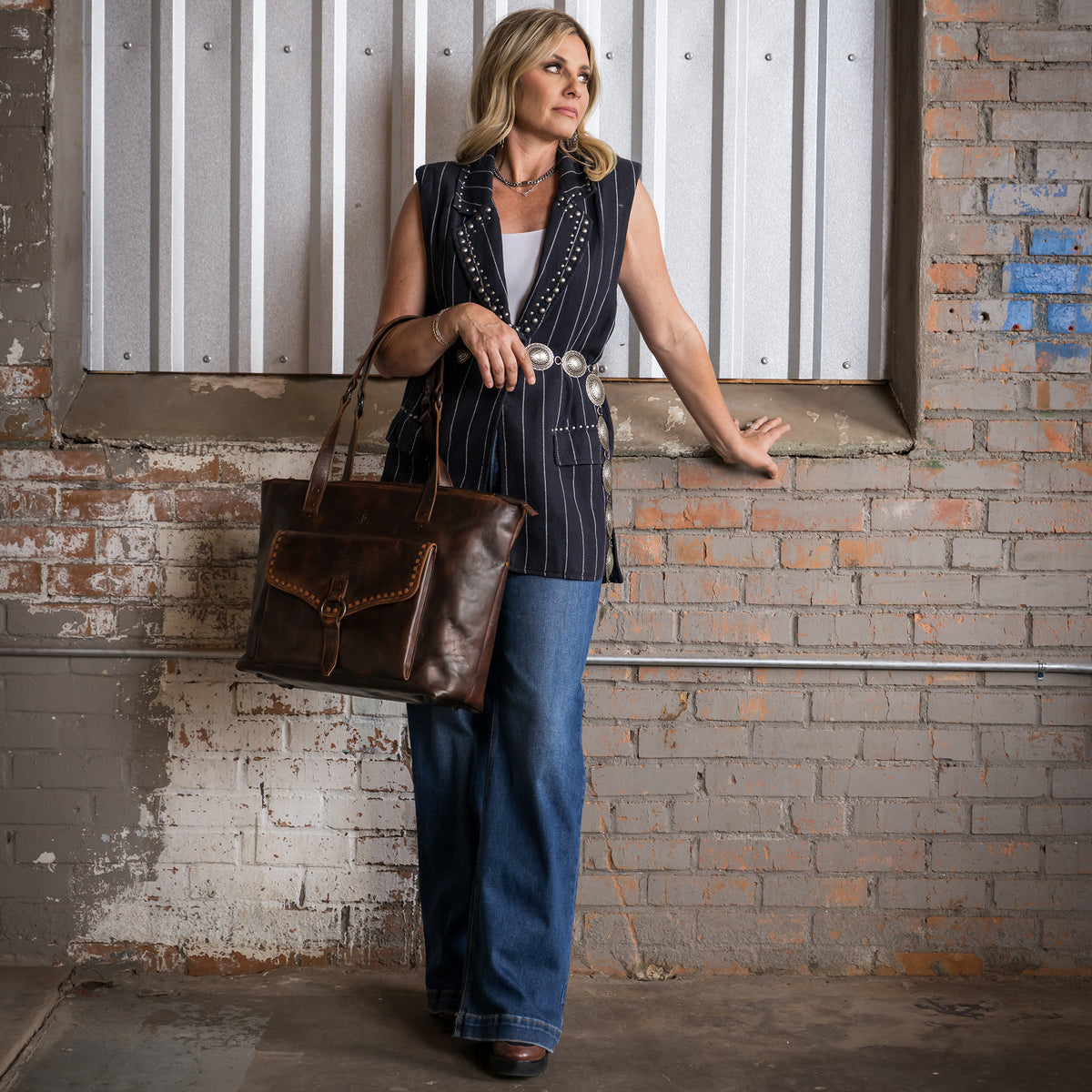 Tiffany Cooper wearing our Bandera chocolate leather tote purse with buckstitch, top zip closure and magnetic buckle front pocket