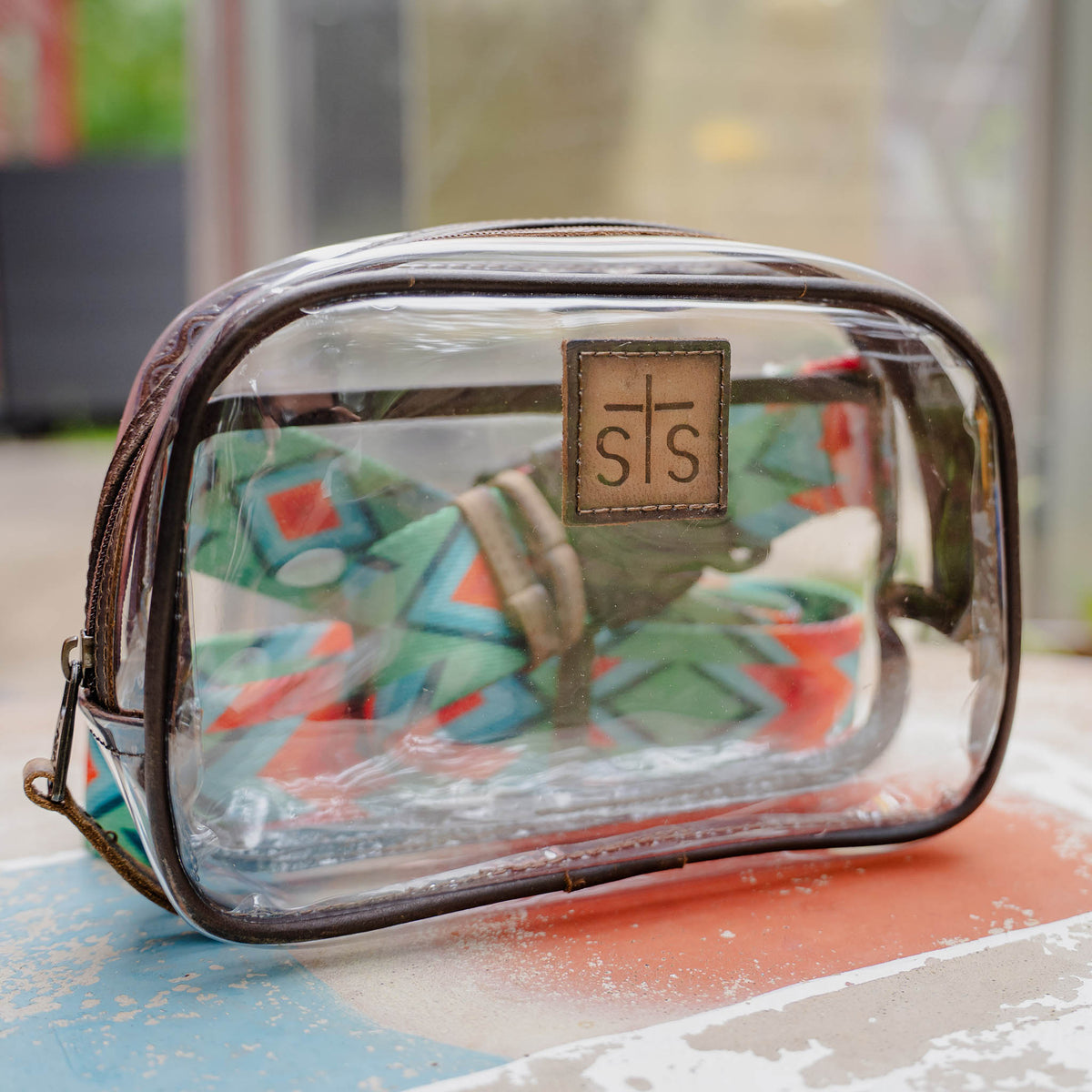 Clear belt bag with brown leather accents and visible brand logo.