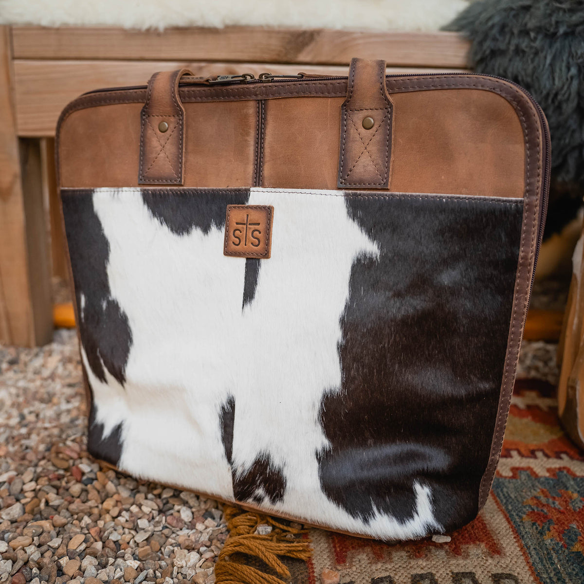 Brown leather shopper bag with brown and white cowhide accents and zip closure.