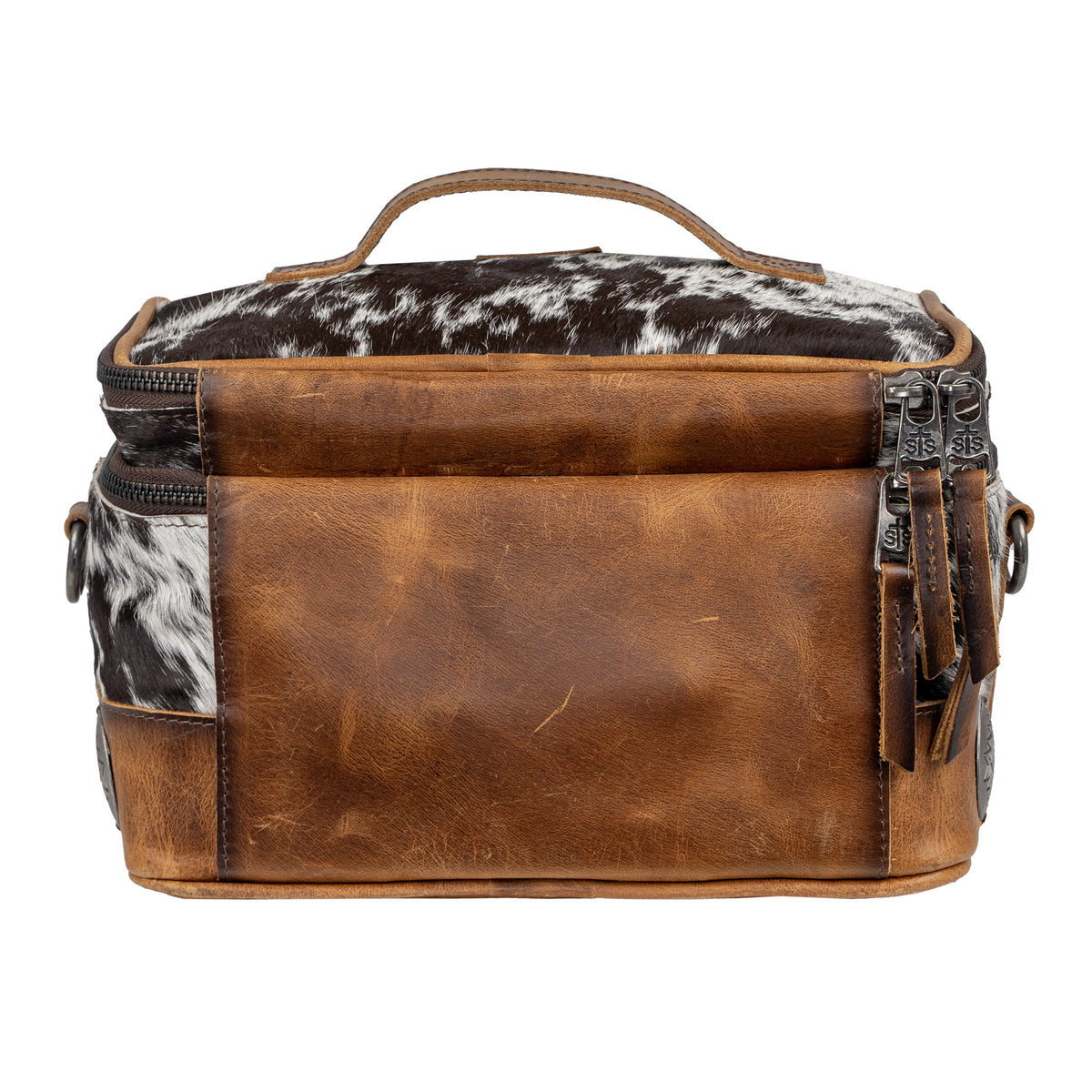 A cowhide makeup organizer with brown leather accents and large rustic conchos, featuring a zip around top closure and leather backing.