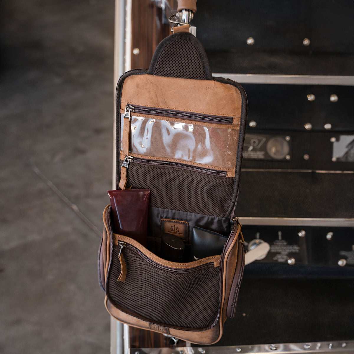 Brown genuine leather hanging shave kit with multiple compartments.