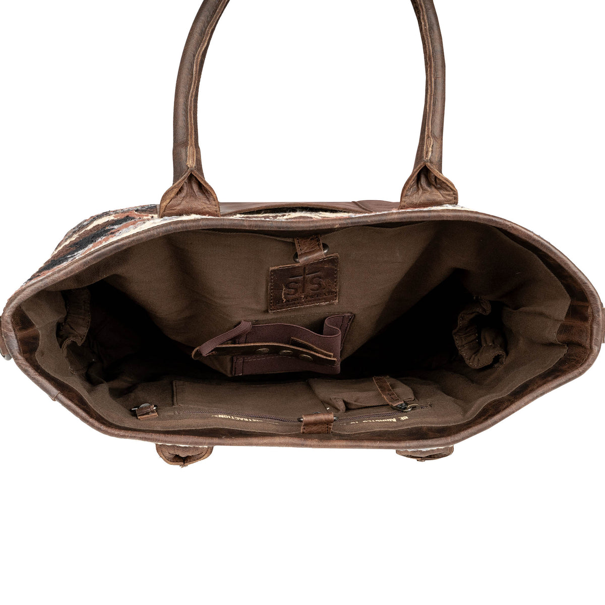 Interior of brown leather handbag with multiple pockets and concealed carry pocket.