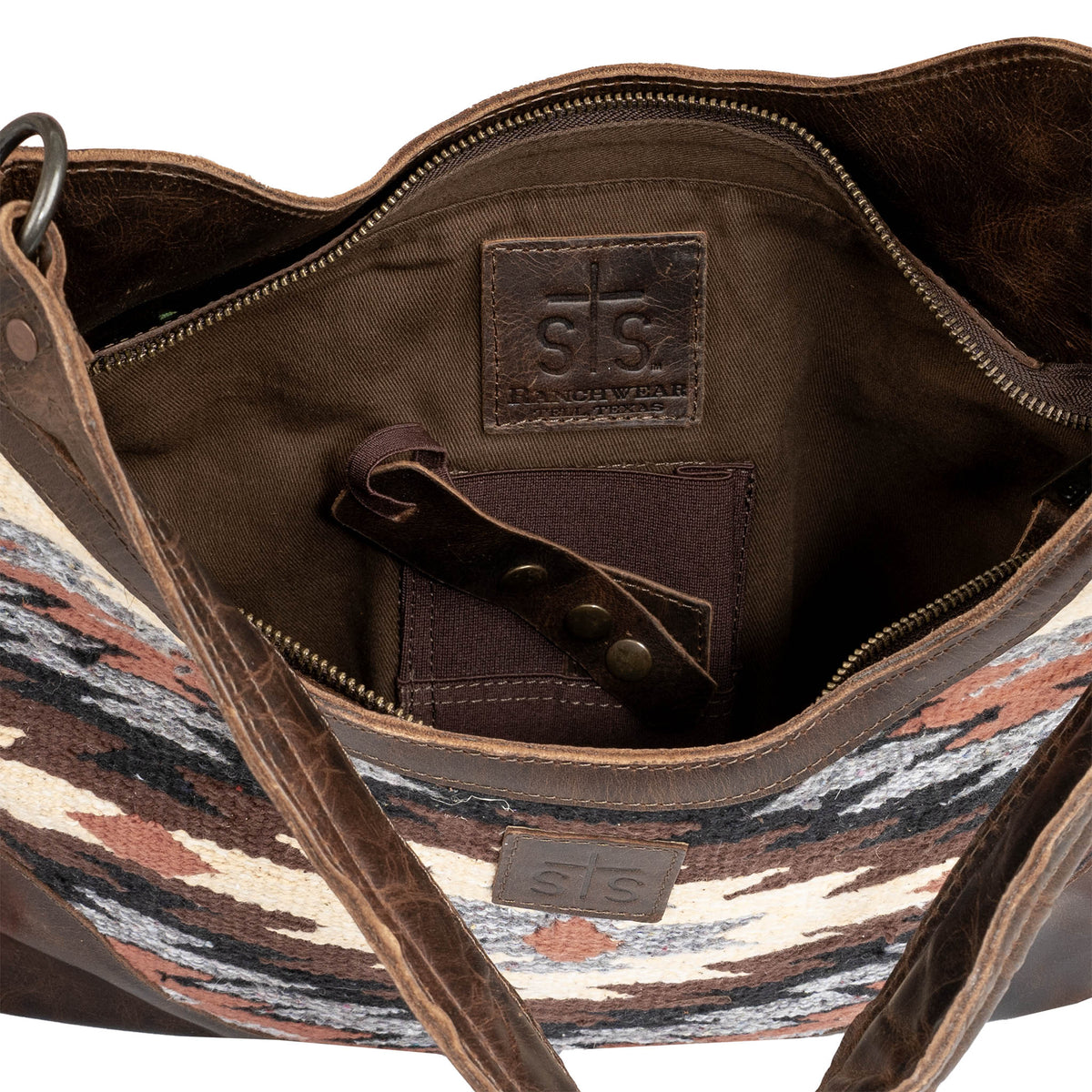 Brown leather bag with interior details, concealed carry pocket and brown leather patch with embossed STS Ranchwear logo.