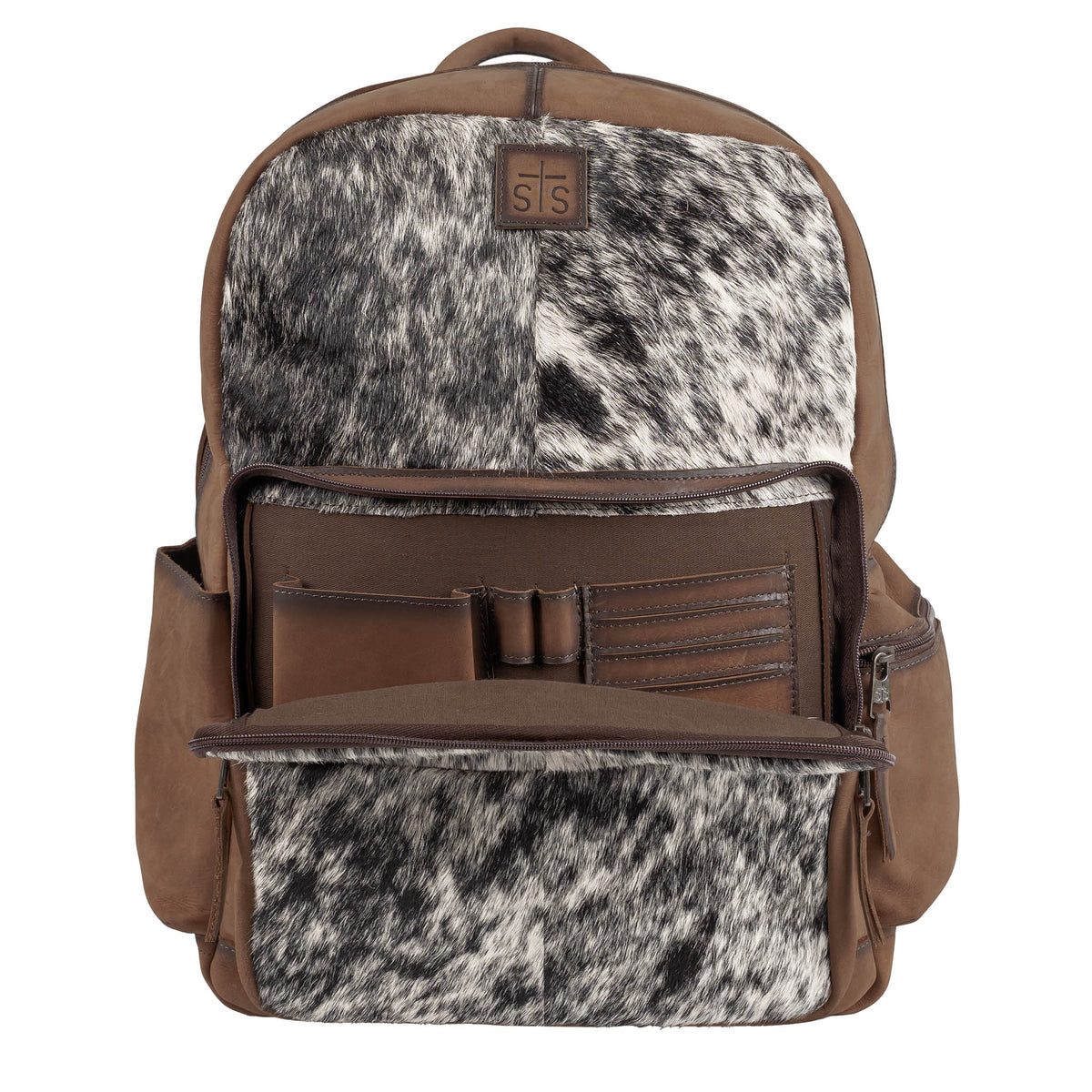 Backpack with brown leather accents and black and white cowhide on a white background.