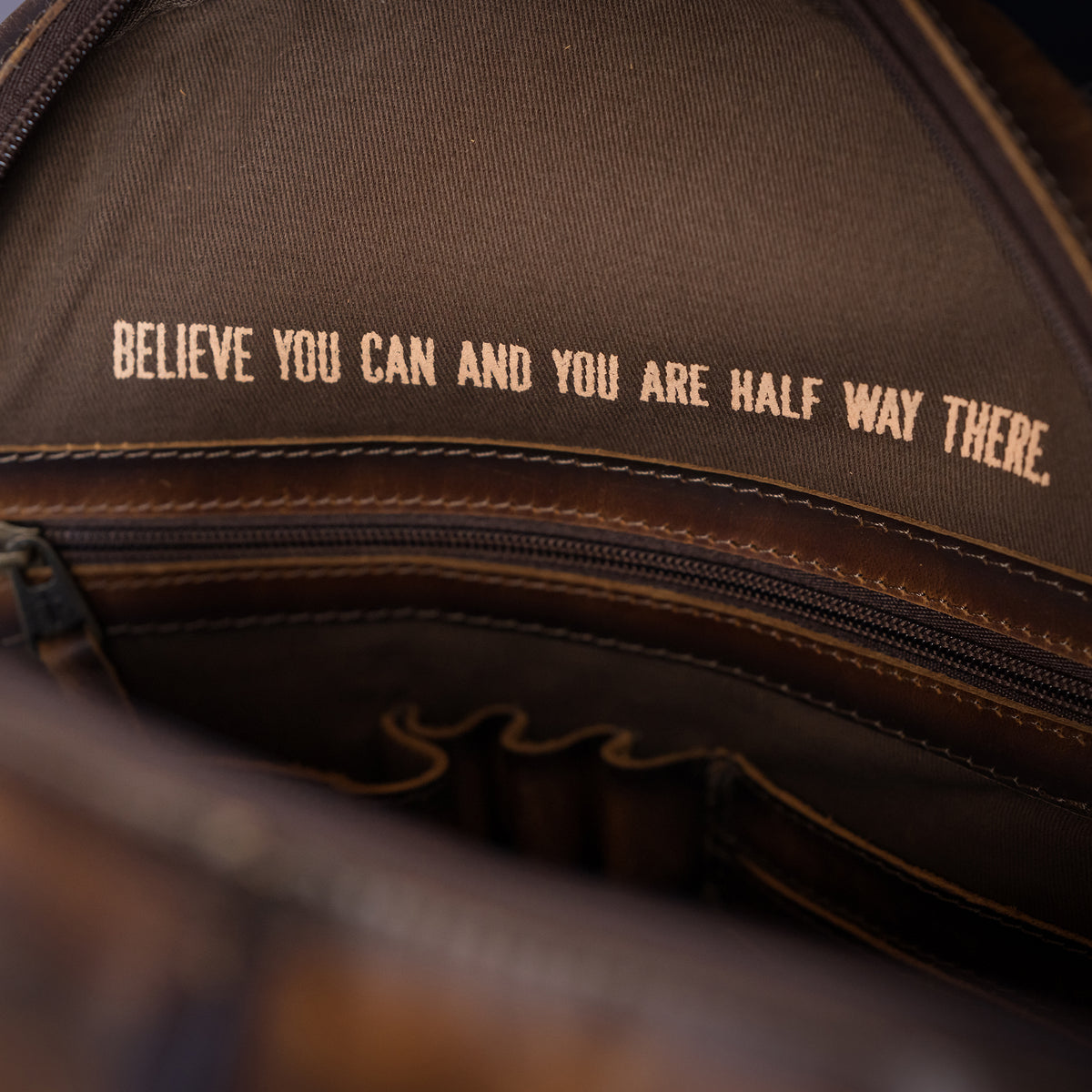 open view of our distressed full grain leather and cowhide backpack with double zip around closure, top carry handle and adjustable straps