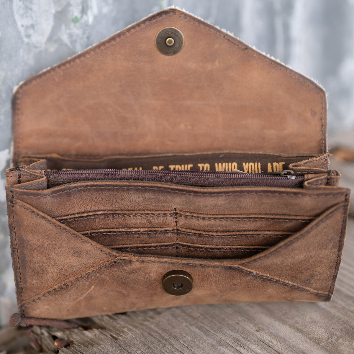 Inside of brown leather wallet with card slots, zip pocket and cash slip.