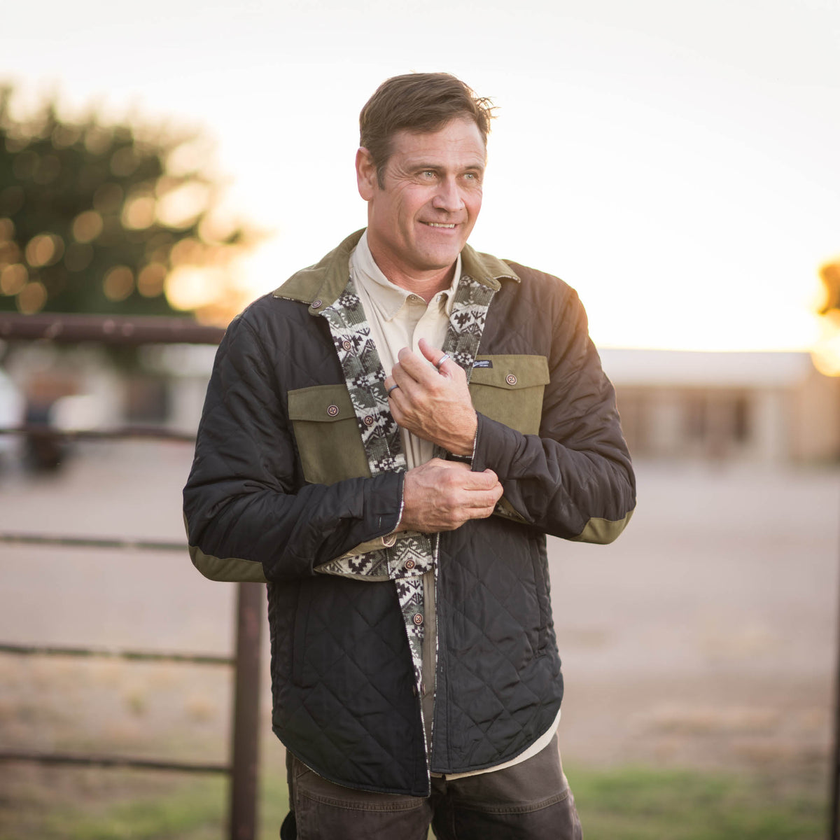 Stran T Smith in an outdoor setting wearing a men's reversible jacket with a green collar and chest pockets and black shell.
