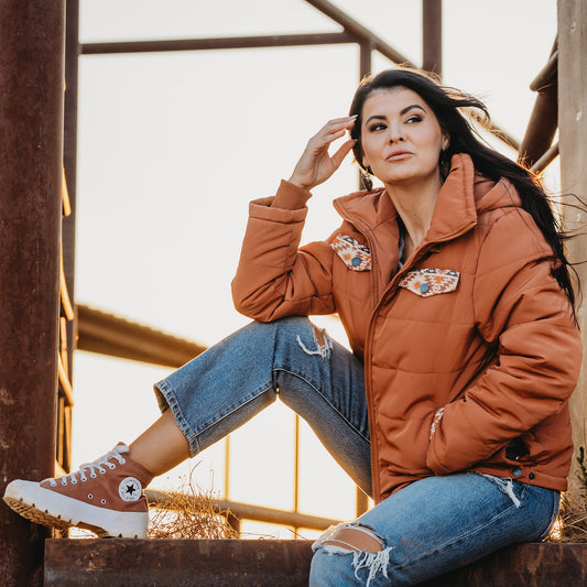 Whitney Vest wearing our rust collared puffer jacket with aztec detailing outside.