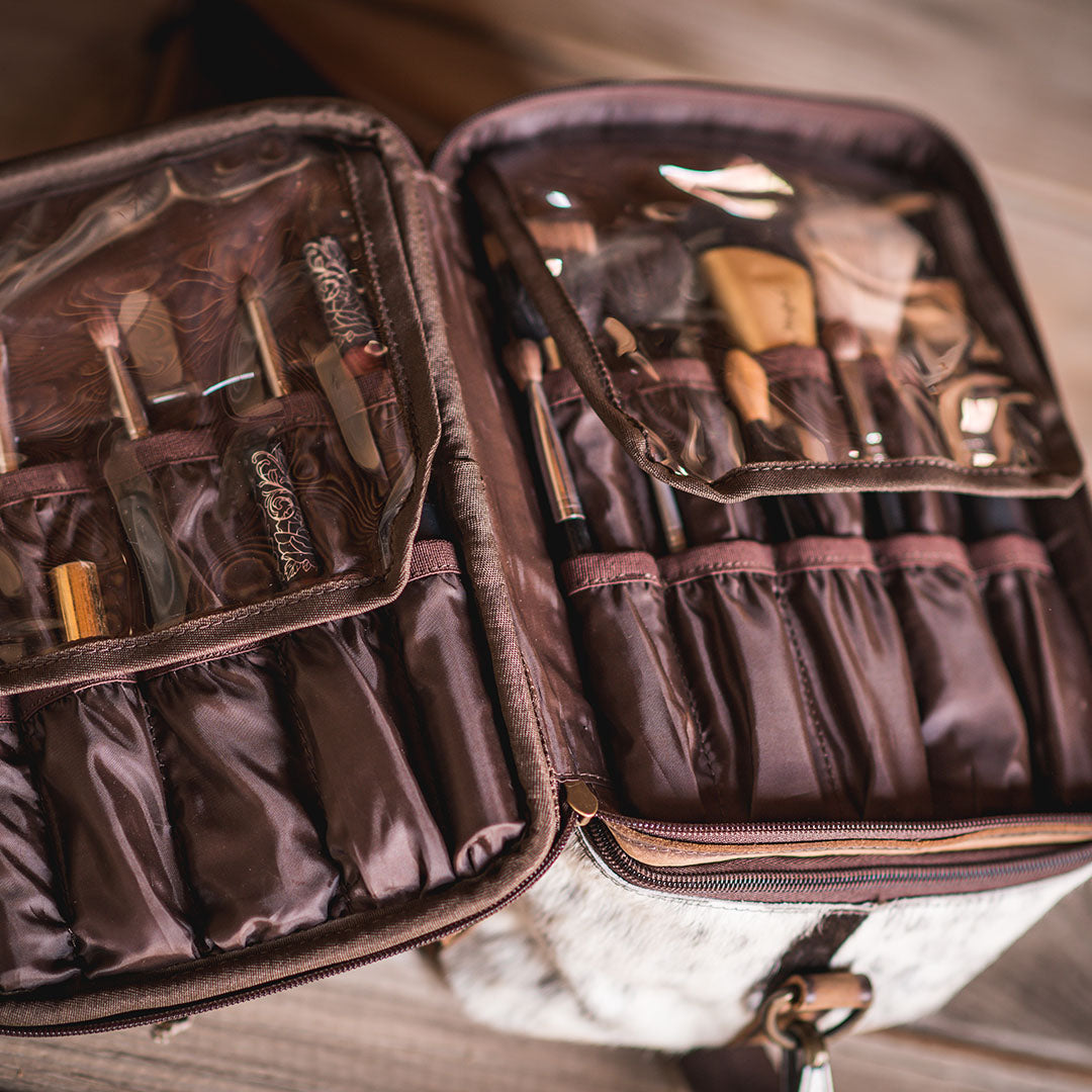 Inside view of hair on hide cowhide cosmetics bag with cosmetics inside.