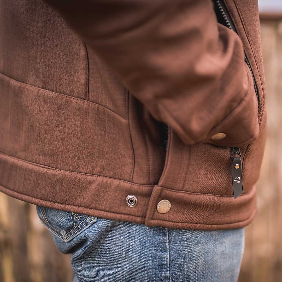 Person wearing a heather brown softshell jacket with their hand in the pocket.