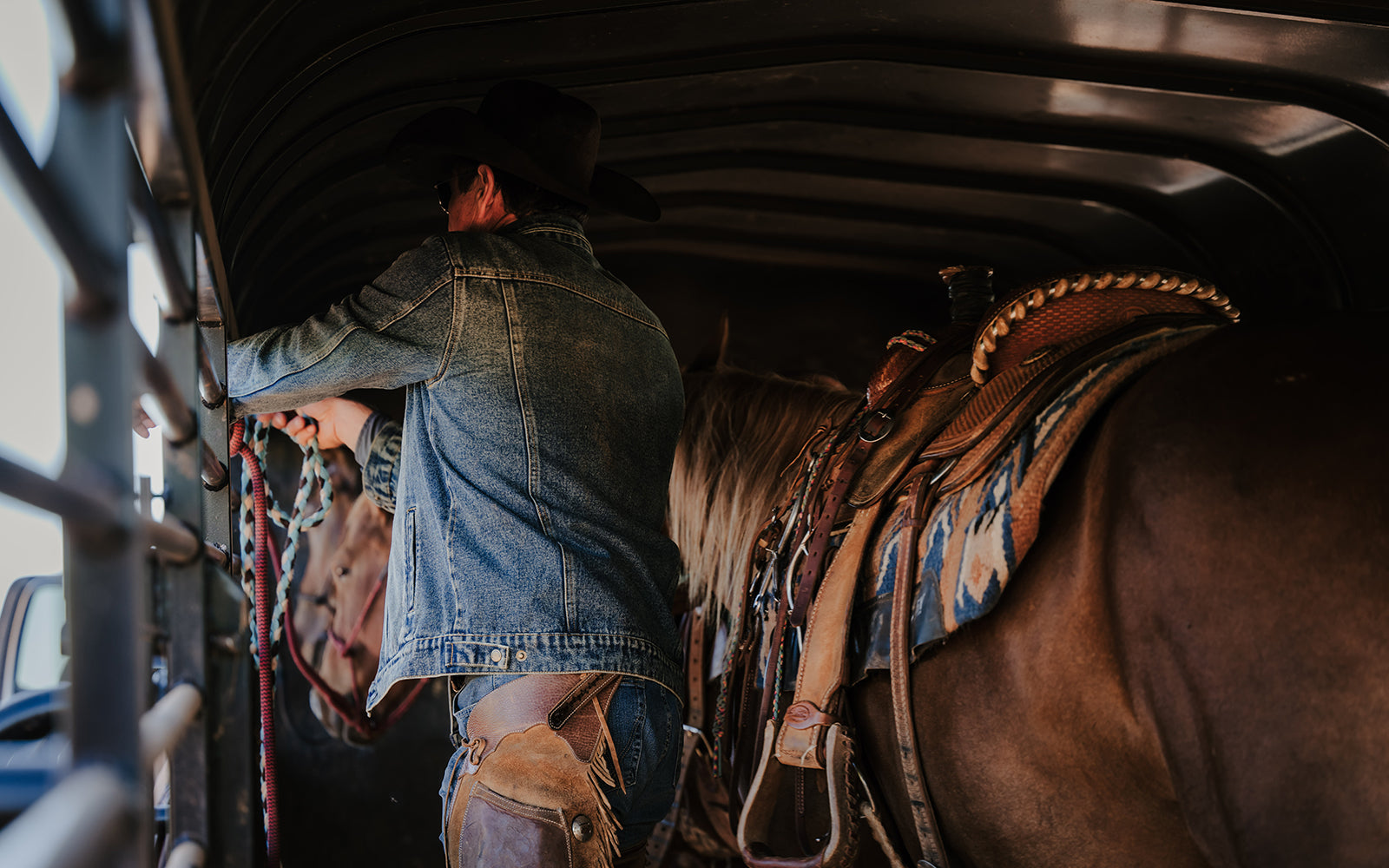 Stran T Smith tends to his horse wearing the men's Caprock denim jacket.
