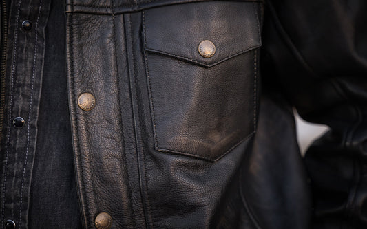 Brown leather jacket with bronze zipper and button.