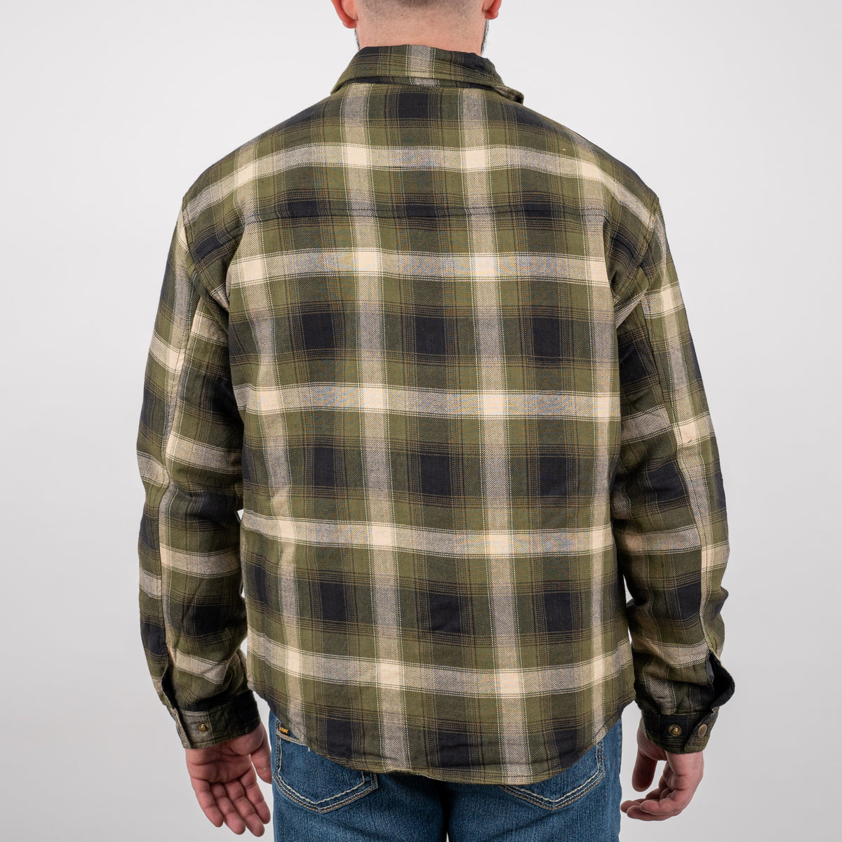 Man facing away wearing a long-sleeved green plaid men's shirt jacket with adjustable snap cuffs on wrists on a gray background.
