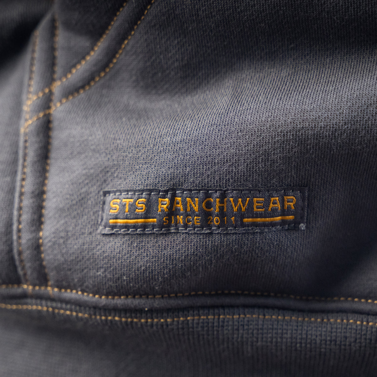 closeup of the bottom of the pocket on our gray quarter zip/snap front closure hoodie with a kangaroo pocket 