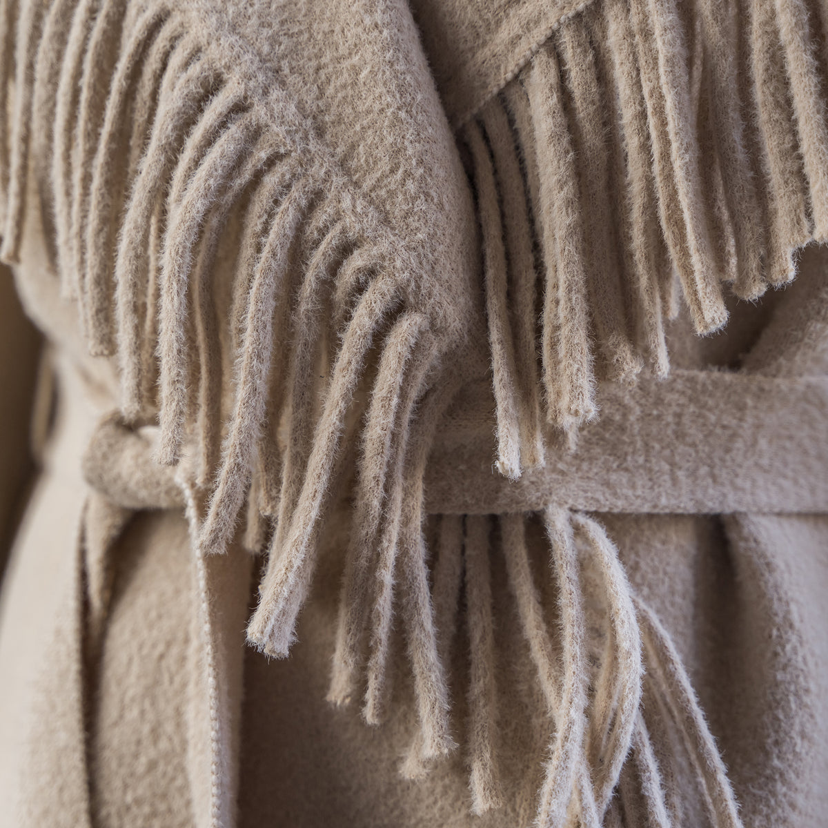 closeup of our beige lapel collared jacket with open front with waist tie belt