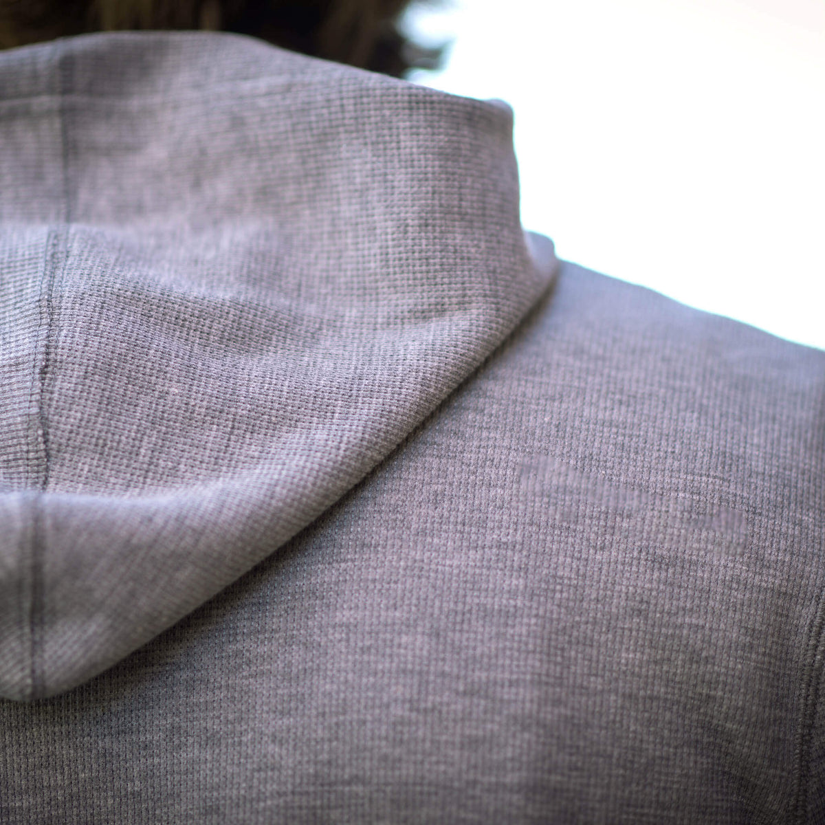 Detail of gray hoodie with hood.