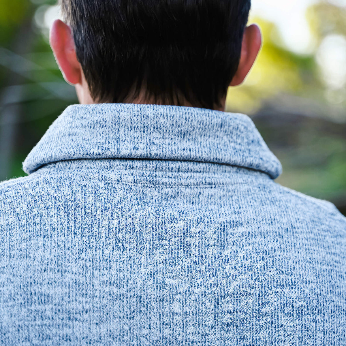 Detail of collar on a men's gray Olathe pullover with button cowl neck.
