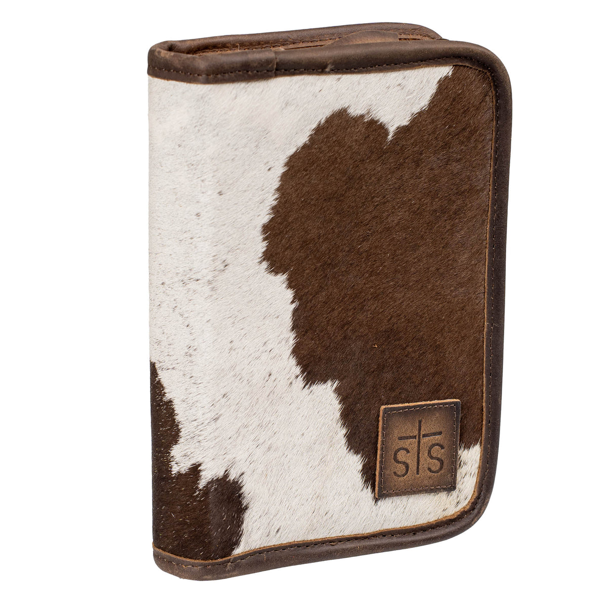Hair on hide cowhide zip closure jewelry case with brown and white accents and a leather STS branded patch in bottom right corner on a white background.