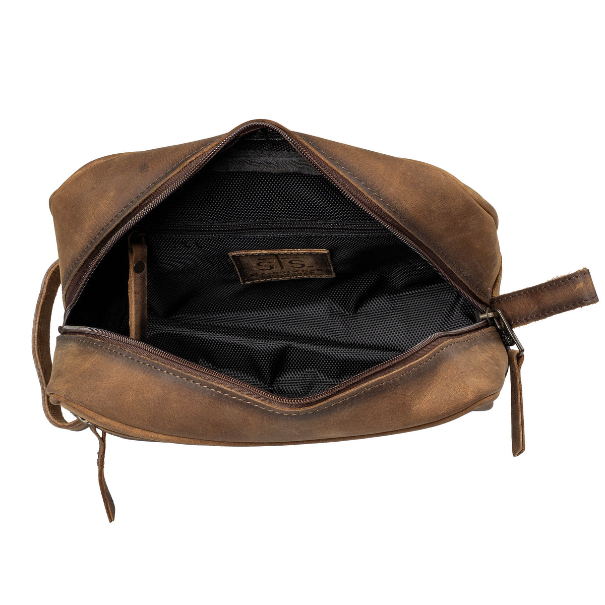 Inside of a brown leather shave kit with canvas lining, zip closure pocket and leather "STS" patch on a white background.