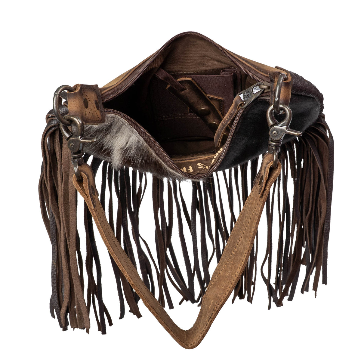 Inside of a genuine leather and hair on hide cowhide shoulder bag with leather fringe and an internal concealed carry pocket on a white background.