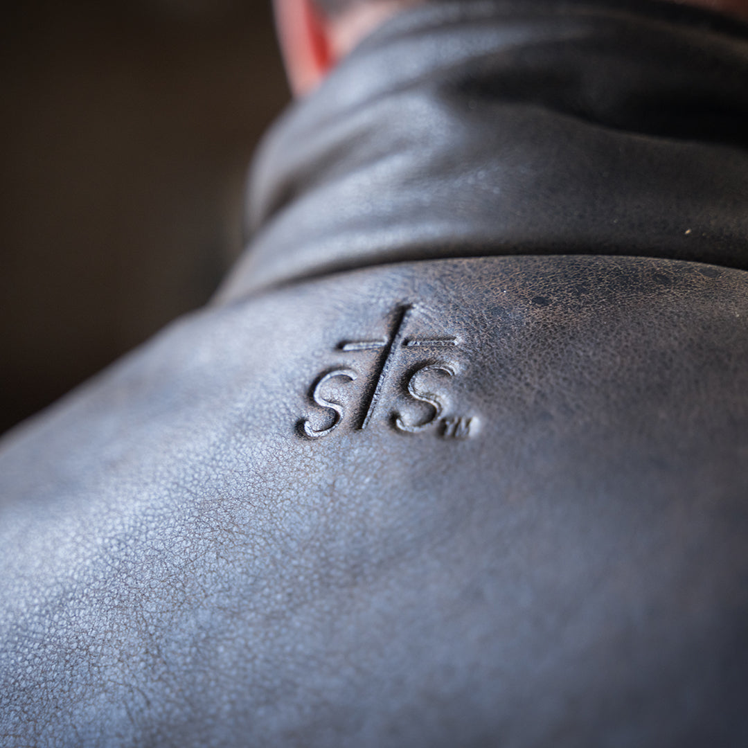 closeup of sts embossed leather yoke on a brown vest