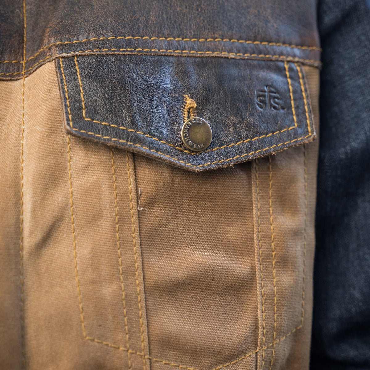 closeup of the front pocket on our snap and zip closure cotton canvas vest with full grain leather accents 