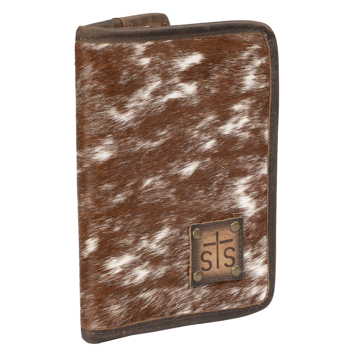 Hair on hide cowhide magnetic closure wallet with brown and white accents and a leather STS branded patch in bottom right corner on a white background.