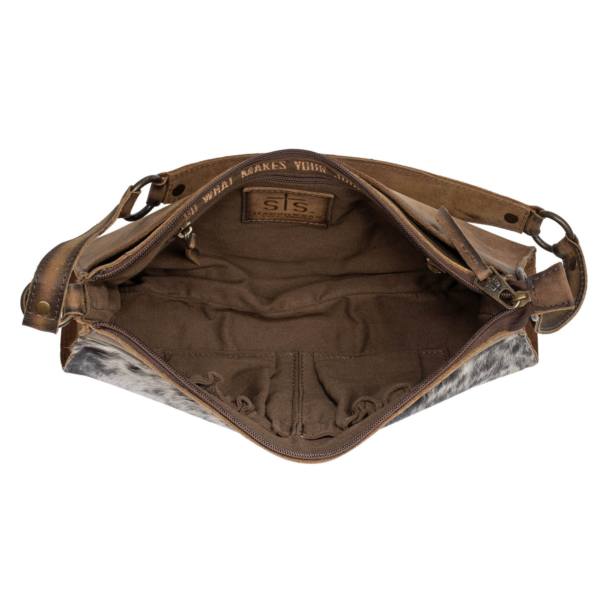 Overhead open view of a cowhide an STS leather shoulder bag on a white background. 