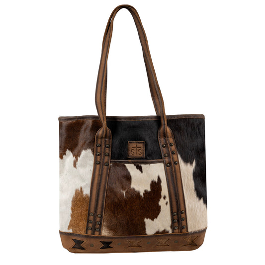 A tote handbag featuring cowhide accents and full grain leather, with dual carry straps and Aztec cut-outs, in assorted colors.