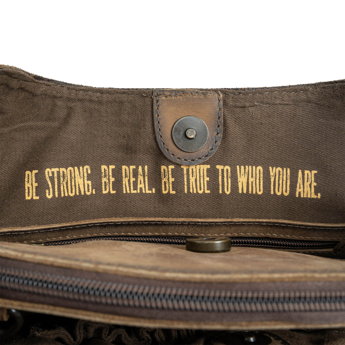 "Be strong. Be real. Be true to who you are" printed on the lining of a leather purse