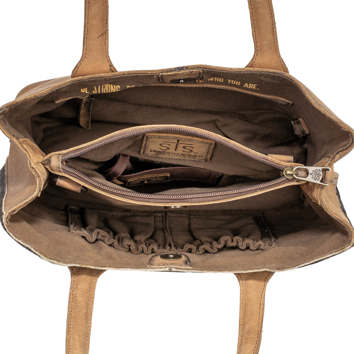 Overhead inside view of the center concealed carry pocket of a leather purse on a white background