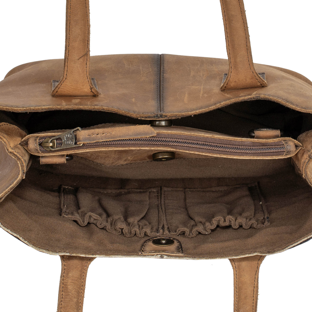 Inside overhead view of a leather purse with half of the bag unsnapped on a white background