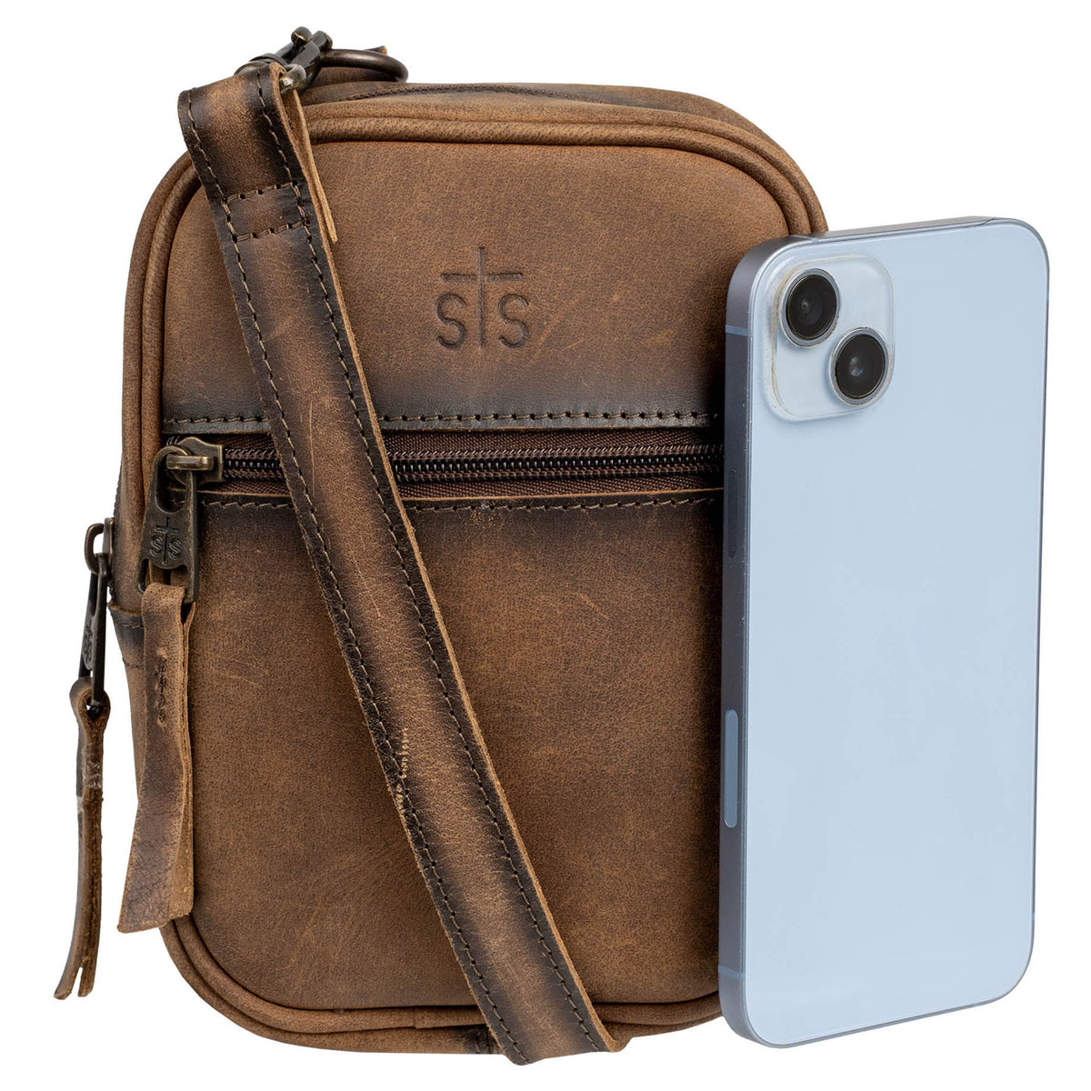 Blue phone propped up against an STS embossed leather crossbody purse on a white background.