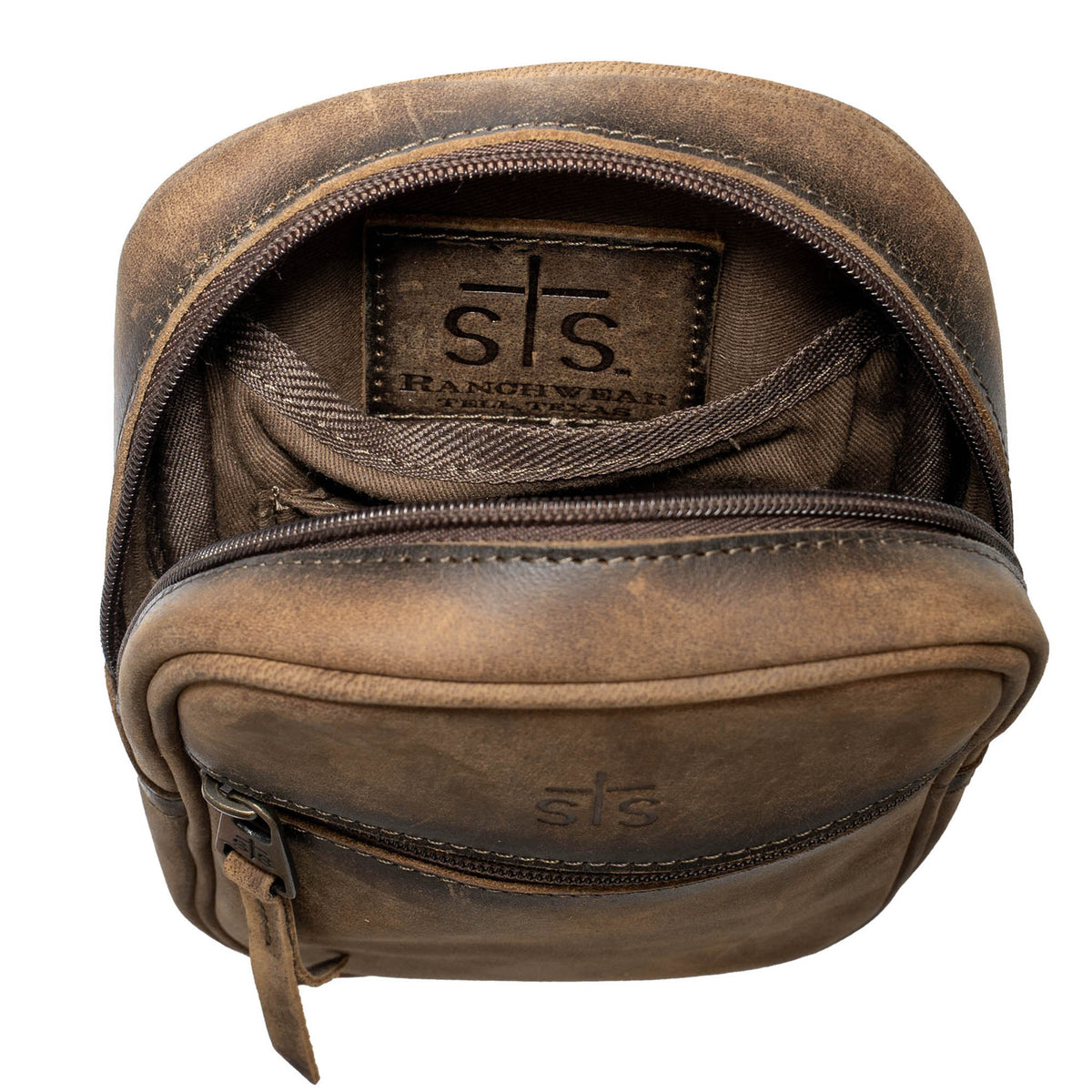 Open view of the internal STS leather patch in a leather crossbody bag on a white background.