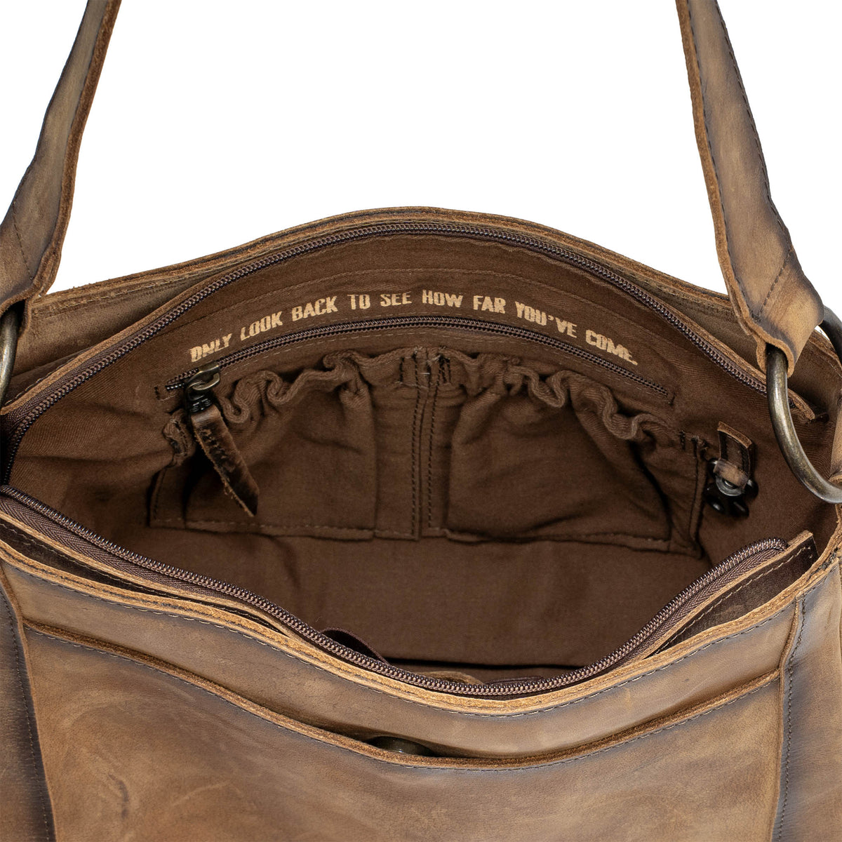 Open view of the storage inside of a leather shoulder bag on a white background.