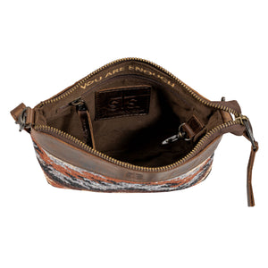 Brown leather crossbody bag with patterned bottom on a white background